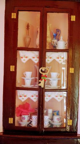 a cabinet filled with cups and dishes in it at Moschos Mansion in Symi