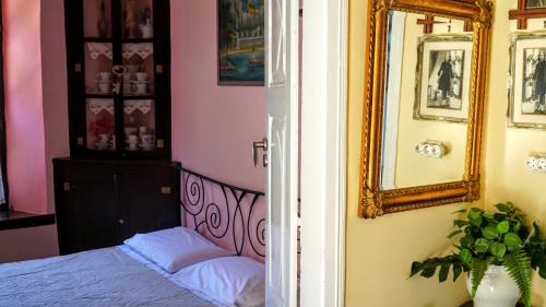 a bedroom with a bed and a mirror at Moschos Mansion in Symi
