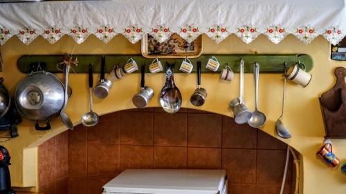 a bunch of utensils hanging on a wall in a kitchen at Moschos Mansion in Symi