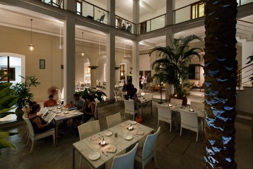 a restaurant with tables and people sitting at them at Villa Shanti - Heritage Hotel for Foodies in Puducherry
