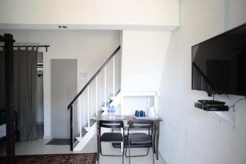 a dining room with a table and chairs and a tv at Tiny Boutique Habitat in Tanah Rata