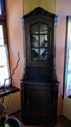 a large wooden cabinet in the corner of a room at Moschos Mansion in Symi
