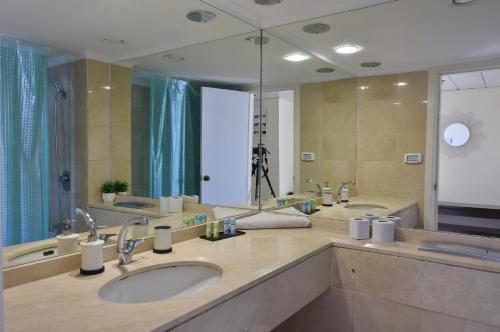 a bathroom with two sinks and a large mirror at Laguna Beach Apartments in Haifa