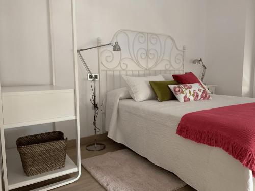 a bedroom with a white bed and a lamp at La Fontina de Luarca in Luarca