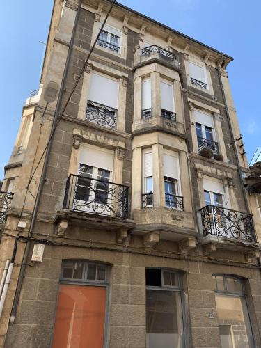 a tall stone building with windows and balconies at La Fontina de Luarca in Luarca