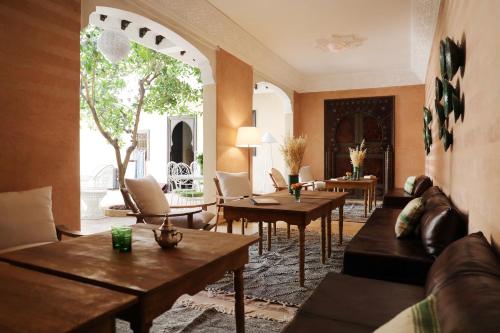 a living room with couches and tables in a room at Riad l'Oiseau du Paradis in Marrakech