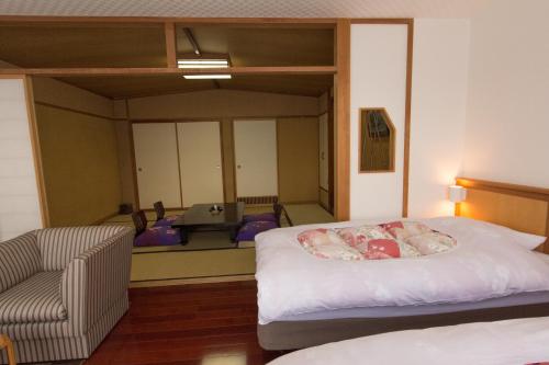a bedroom with a bed and a chair and a desk at Yuzawa Grand Hotel in Yuzawa