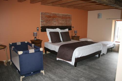 a bedroom with two beds and a chair at LES GALAINES in Abzac