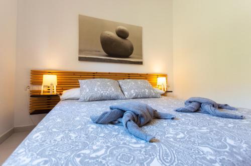 een slaapkamer met een bed met blauwe handdoeken erop bij PoolViewZen-CorralejoPlaya in Corralejo