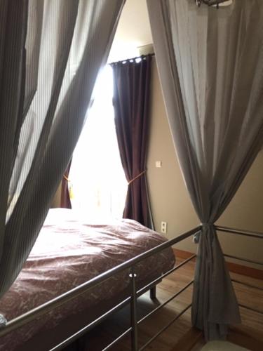 a bedroom with a bed and a window at Holiday Home Family @ home 97 in Bruges