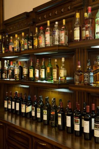 a shelf filled with lots of bottles of alcohol at Dellas Boutique Hotel in Kalabaka