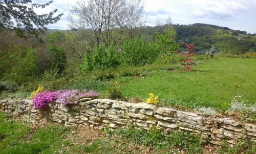 a stone wall with flowers in a field at Villa FRIDA in Rogaška Slatina