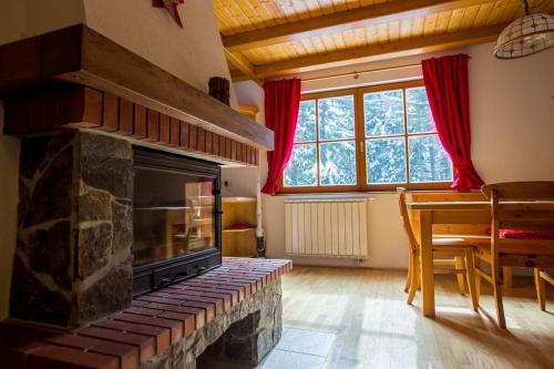 a living room with a stone fireplace and a table at Bolfenk lodge apartment in Pohorje