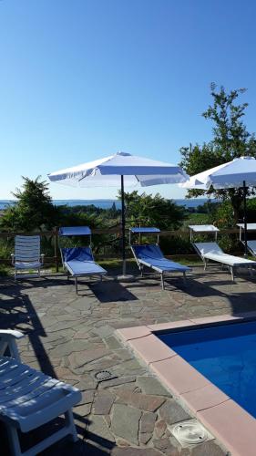 a group of chairs and an umbrella next to a pool at El Rincon del Artista in Soiano del Lago