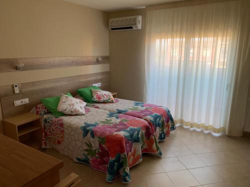 um quarto com uma cama e uma janela em RAQUEL'S - Habitacions i Apartaments turístics - em Sant Pere Pescador