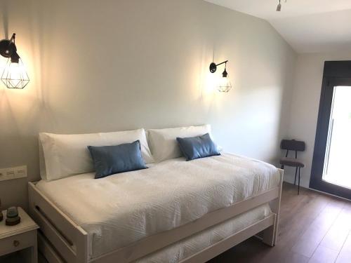 a bedroom with a bed with two blue pillows on it at Apartamentos Turísticos Leiva -La Rioja in Leiva