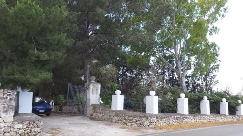 a cemetery with a stone fence and trees at Giardino dei Baroni house in Marina di Mancaversa
