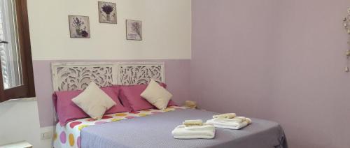 ein Schlafzimmer mit einem Bett mit Handtüchern darauf in der Unterkunft Angolo Verde in Oristano