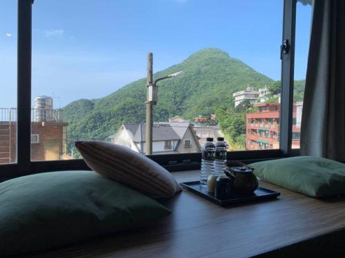 九份にあるM Bar Houseの山の景色を望むテーブル付きの部屋