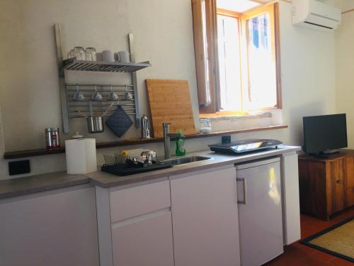 a kitchen with white cabinets and a sink and a window at Vigna del Poggio in Anghiari