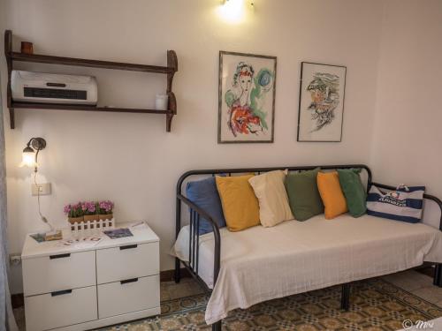 a bedroom with a bed with colorful pillows on it at Rundanina Village Life Studio in Vernazza