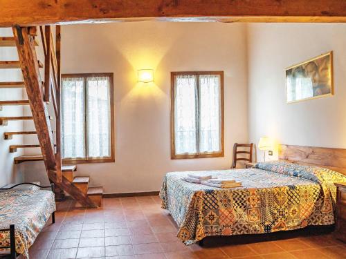 a bedroom with two beds and a staircase and windows at Agriturismo Contea di val d'amone in Brisighella