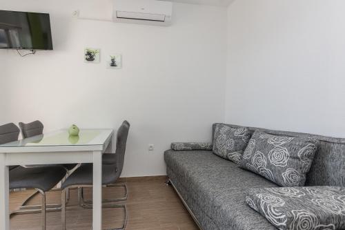 a living room with a couch and a table at Apartmani Jadranka in Starigrad-Paklenica