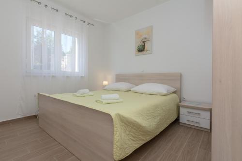 a bedroom with a large bed with two towels on it at Apartmani Jadranka in Starigrad-Paklenica