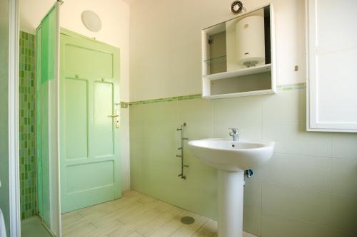 カステッラバーテにあるBaia di Ogliastroのバスルーム(シンク、鏡、ドア付)