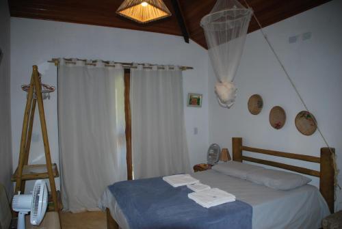 a bedroom with a bed with towels on it at Casa do Capão in Vale do Capao