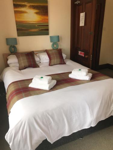 una camera d'albergo con due letti e asciugamani di Garfield Guesthouse a Dingwall