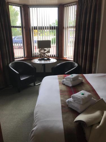 a hotel room with a bed and a table and chairs at Garfield Guesthouse in Dingwall