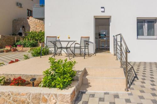 a balcony of a house with a table and chairs at Apartmani Jadranka in Starigrad-Paklenica