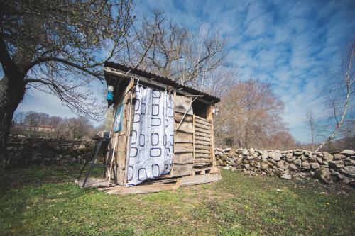 a small wooden out house with a stone wall at Voyage Spatio-Temporel in Poussanges