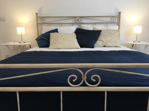 ein großes Bett mit einer blauen Bettdecke und einem Metallrahmen in der Unterkunft A Casa di Clara in Syrakus