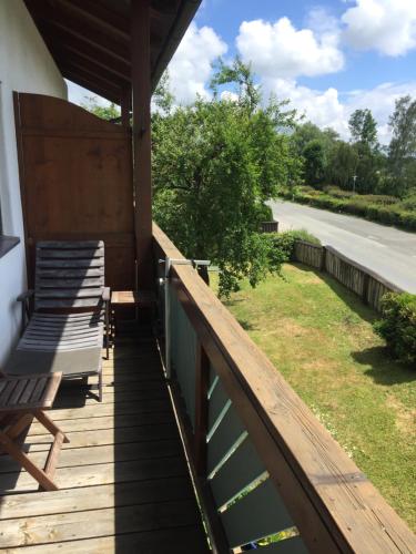 a porch with two chairs and a fence at Ferienwohnung Seebruck am Chiemsee in Seebruck