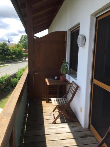 a wooden porch with a chair and a table at Ferienwohnung Seebruck am Chiemsee in Seebruck