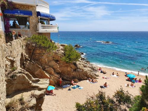 un grupo de personas en una playa cerca del océano en Faro SOLO para MUJERES, en Platja d'Aro