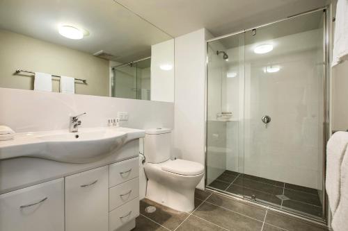 洛坎普頓的住宿－羅克漢普頓之客公寓式酒店，浴室配有卫生间、盥洗盆和淋浴。