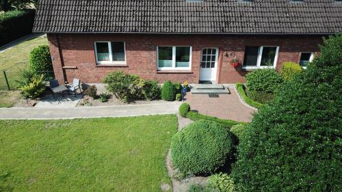 a red brick house with a garden in front of it at Ferienwohnung Gravemeier in Ladbergen
