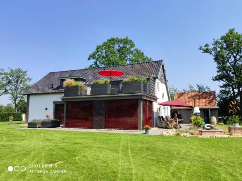 a house with a red umbrella on top of it at LANDLOFT am Paradies in Westerstede