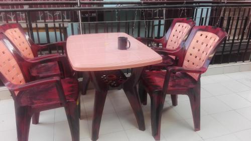 une table avec quatre chaises rouges ainsi qu'une table et des chaises roses dans l'établissement Hotel Sisters Home, à Katmandou