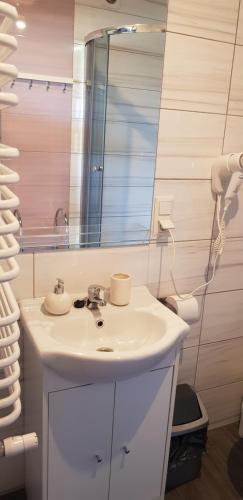 a bathroom with a white sink and a mirror at Apartamenty Maja -Pokoje - Domy wakacyjne -Basen Podgrzewany -Jacuzzi in Łeba