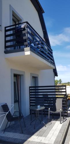 a balcony with two chairs and a table in front of a building at Apartamenty Maja -Pokoje - Domy wakacyjne -Basen Podgrzewany -Jacuzzi in Łeba