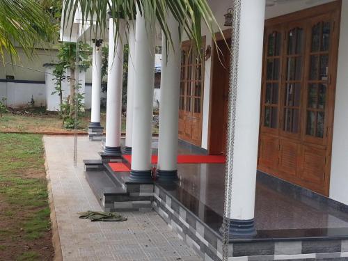 a row of columns on a building with a door at Belhaven Home Stay in Trivandrum