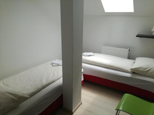 two beds in a room with a green chair at Apartments Club Telgárt in Telgárt