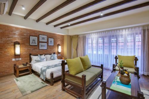 a bedroom with a bed and a chair and a window at Hotel Thamel House - 6 km from Boudhanath Stupa, Kathmandu in Kathmandu