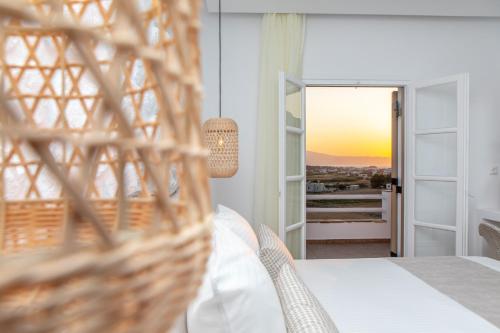 a bedroom with a bed and a view of the sunset at Naxian Pearl in Mikri Vigla