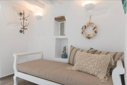 a white bed in a white room with a wreath on the wall at Apollonion house in Apollonia