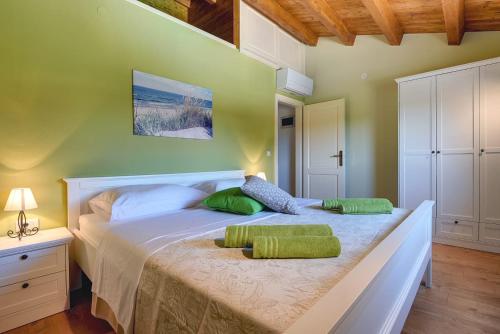 - une chambre avec un grand lit et 2 oreillers verts dans l'établissement Haus Mila, à Pavicini